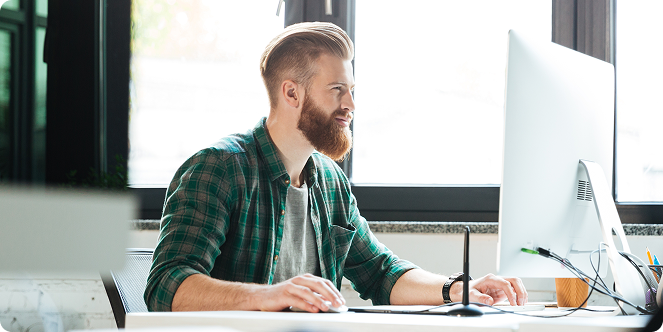 An man sitting in his office looking at his pc. the image must be realistic as a real photo and the man should not be in elegant clothes